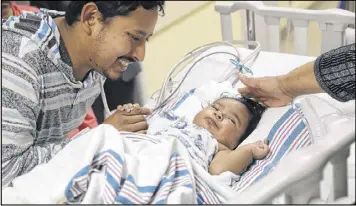  ?? PATRICK SEMANSKY / ASSOCIATED PRESS ?? Hidelberto Salinas Ramos says goodbye to his son, Josue Salinas Salgado, before he is wheeled into open heart surgery at the University of Maryland Medical Center in Baltimore.