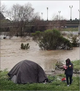  ?? SHMUEL THALER - SANTA CRUZ SENTINEL ?? A camper clears his site Saturday morning from the banks of the swollen Pajaro River. County officials gave a tentative date of Friday for residents to reenter their homes. .