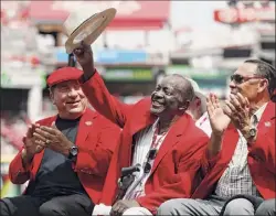  ?? John Minchillo / Associated Press ?? In this 2017 photo, former Cincinnati Reds player Joe Morgan, center, waves to the crowd as he attends a pregame statue dedication ceremony for teammate Pete Rose at Great American Ball Park in Cincinnati. Morgan is joined by fellow members of the Big Red Machine, Johnny Bench, left, and Tony Perez.