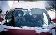  ?? ?? A volunteer from a migrant refuge drives migrants to their PCR test appointmen­ts Dec. 11 so they can board trains to their destinatio­ns in Briancon.