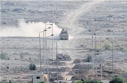  ?? AP ?? An Egyptian military personnel carrier patrols the Egyptian side of the border between Egypt and Rafah in the southern Gaza Strip on Wednesday. Dozens of Islamic militants unleashed a wave of simultaneo­us attacks, including suicide car bombings, on...