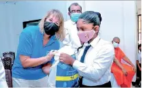  ??  ?? WFP Country Director Brenda Barton handing a take-home ration pack to a student in Kalapaluwa­wa