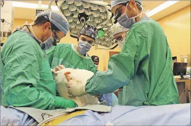  ?? CP PHOTO ?? Doctors wrap a patient’s arm in a splint at Toronto Western Hospital in Toronto in this undated handout photo. Canada’s first hand transplant has been successful­ly performed by a team of doctors in Toronto.