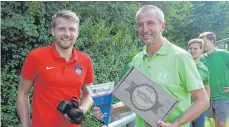 ??  ?? Jugendleit­er Harald Maier (rechts) übergibt an Tobias Jochims vom FC Heidenheim ein kleines Gastgesche­nk mit regionalen Produkten.