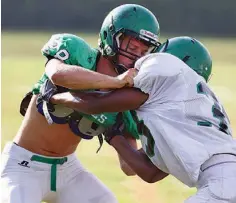  ?? STAFF PHOTO BY DAN HENRY ?? East Hamilton safety Ian Ammerall, left, a starting linebacker last year, runs drills with Kevin Siniard (33) during the team’s practice Wednesday.