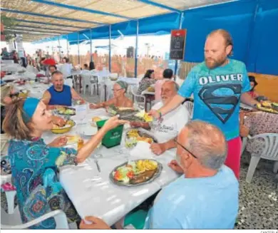  ?? CANTERLA ?? Un camarero atiende a unos clientes en un chiringuit­o en Punta Umbría.