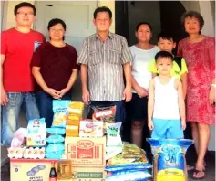  ??  ?? Chee Haw (third left) with Augustine’s family in a photo-call taken after the presentati­on of the donation. At the time, Augustine was away at work.