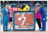  ?? REUTERS ?? Usain Bolt receives a piece of the running track during his farewell ceremony on Sunday.