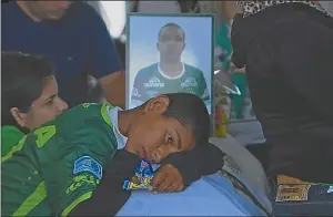  ??  ?? VENCIDO. El dolor del hijo de uno de los jugadores junto al féretro. “Todos somo