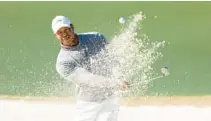  ?? WARREN LITTLE/GETTY ?? Tiger Woods plays a shot from a bunker during the continuati­on of the first round of the Masters on Friday at Augusta National Golf Club in Augusta, Georgia.
