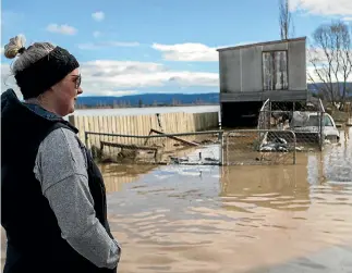  ?? PHOTOS: GEORGE HEARD/STUFF ?? Emma McGregor takes in the sight of her family’s submerged Henley property.