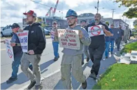  ?? AP PHOTO/JOSH REYNOLDS ?? Justin Paetow, center, a tin shop worker at Bath Iron Works, takes part in a demonstrat­ion against a COVID-19 vaccine mandate outside the shipyard on Friday in Bath, Maine.