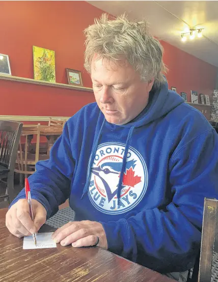  ?? COREY LEBLANC/SALTWIRE NETWORK ?? Russell Welsh writes while having his morning coffee at the Tall and Small Café in downtown Antigonish.