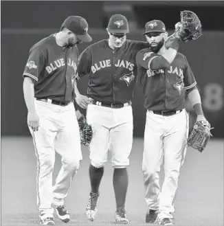  ?? Frank Gunn Associated Press ?? BRETT CECIL, center, is led off the field by Toronto Blue Jays teammates Chris Colabello, left, and Jose Bautista after suffering a torn calf muscle in Game 2 of series with the Texas Rangers.