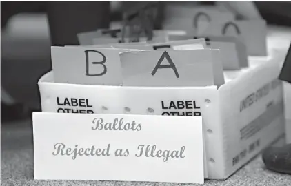  ?? Associated Press ?? ■ Rejected mail in ballots sit in a box Tuesday as members of the canvassing board verify signatures on ballots at the Miami-Dade County Elections Department in Miami. Voters go to the polls in the midterm elections Tuesday.