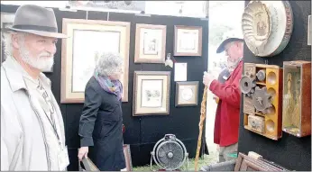  ?? Keith Bryant/The Weekly Vista ?? David Curles, left, stands by as his wife, Christina Smith talks with a customer in their booth at this year’s Arts and Crafts Festival. The couple lives in Bella Vista, and while it was Curles’ first time exhibiting, Smith said she’s been coming to...