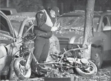  ?? Photograph­s by Stepan Franko European Pressphoto Agency ?? A POLICEMAN at the bombing scene in Kiev. Authoritie­s said the bomb was attached to a motorcycle.