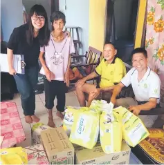  ??  ?? Pungut (second from left), Chang (second from right) are all smiles after receiving the much needed items from Wan (right) and a volunteer.