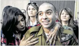  ?? JIM HOLLANDER / AP ?? Israeli soldier Elor Azaria is embraced by his mother at the start of his sentencing hearing in Tel Aviv, Israel, on Tuesday. The court sentenced Azaria to 18 months in prison for the fatal shooting of a wounded Palestinia­n assailant.