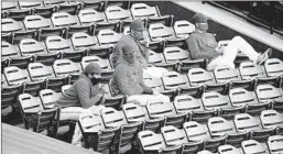  ?? KELVIN KUO/AP ?? Angels players wear face masks while watching a game from the stands Tuesday.