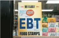  ?? SCOTT HEINS/GETTY ?? A sign alerting customers about SNAP food stamp benefits is displayed at a Brooklyn grocery store in New York City. On March 1, the federal government curtailed enhanced SNAP benefits for 32 states, including Maryland, provided as part of the COVID-19 emergency response.