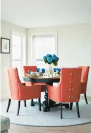  ?? JARED KUZIA ?? “The orange dining chairs in this airy waterfront dining room are from Kravet,” says Jillian Hayward Schaible, who adds it’s worth investing in pieces you sit, sleep and eat on.