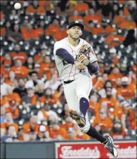  ?? David J. Phillip The Associated Press ?? Houston shortstop Carlos Correa throws to first for the out after fielding a ground ball by Seattle’s Mitch Haniger during the fourth inning of the Astros’ 8-6 win Saturday in Houston.