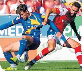  ??  ?? Callum Lang almost loses his Shrewsbury Town shirt in a game against Rotherham