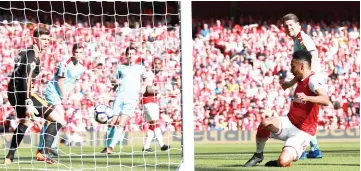  ?? — Reuters photo ?? Pierre-Emerick Aubameyang (right) scores their first goal during the English Premier League match between Arsenal and Burnley at the Emirates Stadium in London.