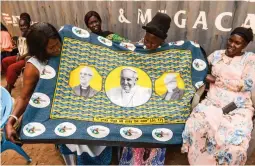  ?? (AFP) ?? POPE VISIT — South Sudanese women hold a printed fabric showing the portrait of Pope Francis (center) as preparatio­ns continue ahead of his visit in Juba. Pope Francis' visit in South Sudan is planned from Feb. 3 to 5.