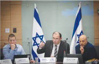  ?? (Yonatan Sindel/Flash90) ?? MK SIMCHA ROTHMAN, the chairperso­n of the Knesset Constituti­on, Law and Justice Committee, is flanked by committee officials as he presides over a session, last week.