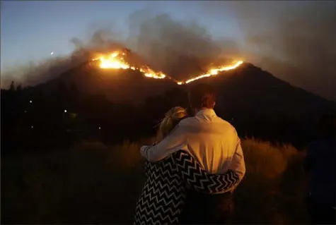  ?? Marcio Jose Sanchez/Associated Press ?? Roger Bloxberg, right, and his wife, Anne, watch a wildfire on a hilltop near their home in West Hills, Calif. in November.