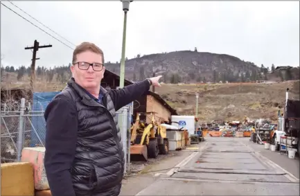  ?? STEVE MACNAULL/The Okanagan Weekend ?? City of Kelowna civic operations manager Stephen Bryans points through Knox Mountain Metals to the section of hillside that’s already partially broken away and poses the greatest risk of a landslide at Ethel Street and Bay Avenue below Royal View Drive...