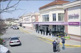  ?? MARY ALTAFFER — THE ASSOCIATED PRESS ?? Officials meet at the scene of a shooting at a Stop & Shop supermarke­t Tuesday in West Hempstead, N.Y. The gunman, who was apprehende­d, shot and killed a store manager.