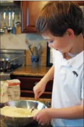  ?? PHOTO BY EMILY RYAN ?? A chef-in-training prepares cake for the trifle.