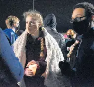  ?? MARY COMPTON/DAILY SOUTHTOWN ?? Taylor Trojan, a senior at Marian Catholic, holds her hand over a candle during the vigil.