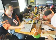  ?? Al Behrman / Associated Press ?? Brian Sherman, left, using his laptop to record moves in his team’s fantasy football draft, is at a Buffalo Wild Wings restaurant in Cincinnati in 2010.