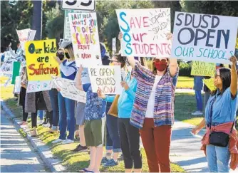  ?? EDUARDO CONTRERAS U-T ?? Parents and students rally for reopening schools outside the San Diego Unified School District Board of Education Headquarte­rs on Tuesday in San Diego.