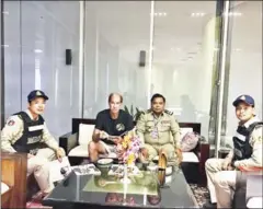  ?? IMMIGRATIO­N POLICE ?? James Ricketson sits with Immigratio­n Police officers at Phnom Penh Internatio­nal Airport on Sunday.