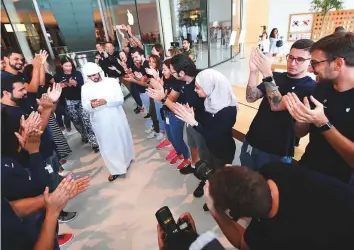  ?? Antonin Kélian Kallouche/Gulf News ?? Top: Bakhit from Abu Dhabi, the first online customer to pre-order the new iPhone, is applauded by staff at the Apple Store in Dubai Mall yesterday. Right: Shoppers check out the iPhone Xs and iPhone Max yesterday.