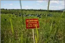  ?? MAIKA ELAN — THE ASSOCIATED PRESS FILE ?? In this file photo, a warning sign stands in a field contaminat­ed with dioxin near Danang airport, during a ceremony marking the start of a project to clean up dioxin left over from the Vietnam War, at a former U.S. military base in Danang, Vietnam. The sign reads; “Dioxin contaminat­ion zone - livestock, poultry and fishery operations not permitted.” Vietnam and the United States have finished cleaning up dioxin contaminat­ion at the airport caused by the transport and storage of the herbicide on and around the area.