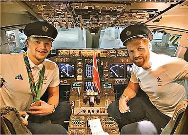  ??  ?? Top guns: Swimmer Adam Peaty and rower Will Satch wearing flight crew hats in the cockpit