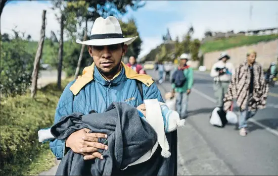  ?? LUIS ROBAYO / AFP ?? El venezolano Richard Lomelly camina con su bebé Tiago por la carretera Panamerica­na en Colombia de camino hacia Perú