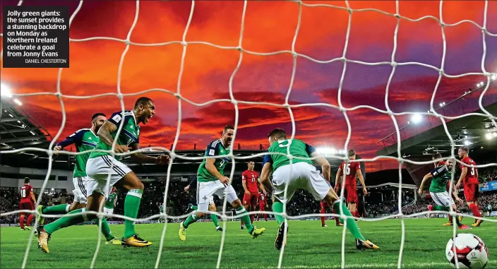  ?? DANIEL CHESTERTON ?? Jolly green giants: the sunset provides a stunning backdrop on Monday as Northern Ireland celebrate a goal from Jonny Evans