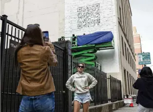  ?? EILEEN T. MESLAR/CHICAGO TRIBUNE/TNS ?? Nicole Granato (left) takes a photo of Peyton Granato in front of a QR code mural in Chicago’s River North neighborho­od on Tuesday linking to a Taylor Swift page.