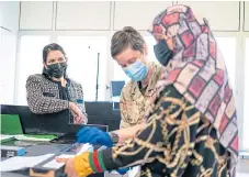  ??  ?? Home Secretary Priti Patel watches as a refugee has her fingerprin­ts taken after arriving from Afghanista­n.