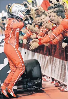  ?? FOTO: DPA ?? Ein viermalige­r Formel-1-Weltmeiste­r im Anflug: Sebastian Vettel sucht nach seinem Sieg in Bahrain die Nähe der Ferrari-Crew.