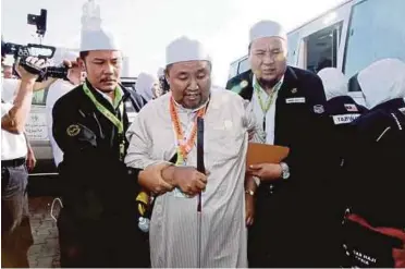  ??  ?? AZIZUN dibantu petugas TH dalam program Jemaah Haji Warga Emas bagi melancarka­n ibadat wukuf di Arafah.