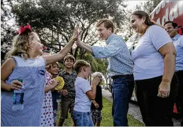  ?? ALLEN EYESTONE / THE PALM BEACH POST ?? Whitney K. Wedgworth, 6, of Wellington, high-fives Republican gubernator­ial candidate Adam Putnam as he and his wife, Melissa, and Lt. Gov. Carlos Lopez-Cantera arrive for a rally Wednesday at the South Florida Fairground­s.