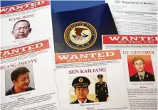  ?? Charles Dharapak / Associated Press ?? Wanted posters depict four of the five Chinese hackers who were charged with economic espionage by a U.S. grand jury in 2014. Hacking is just one method of espionage employed by China.
